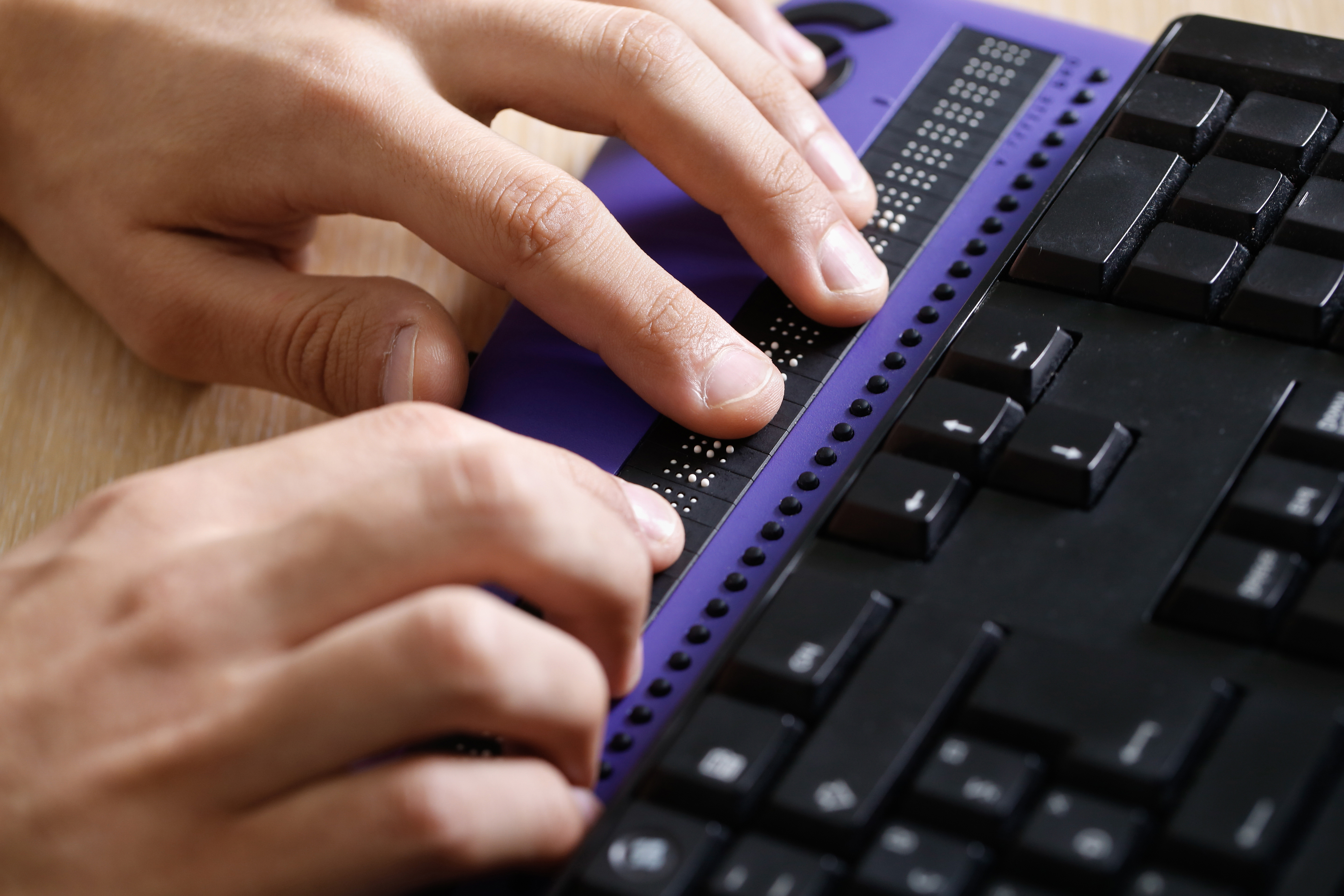 Person's hands using a refreshable braille display