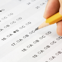 Person marking answers on an exam using a pencil